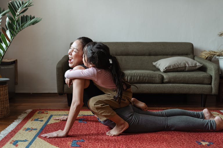 A cheerful mother and daughter bonding during a vibrant yoga session in a cozy living room.