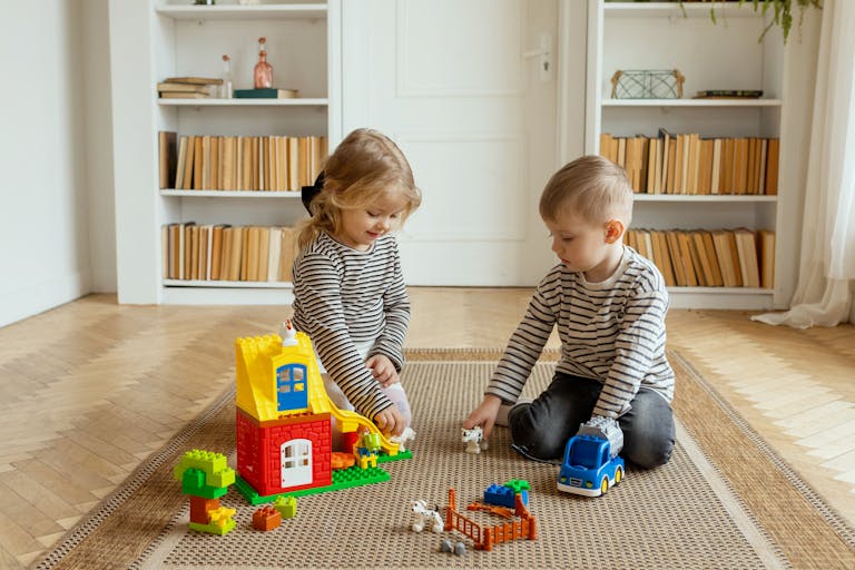 Two children enjoying playtime with colorful building toys in a cozy living room.